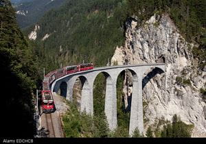 Red train crosses huge viaduct on Switzerland's Glacier Express route
